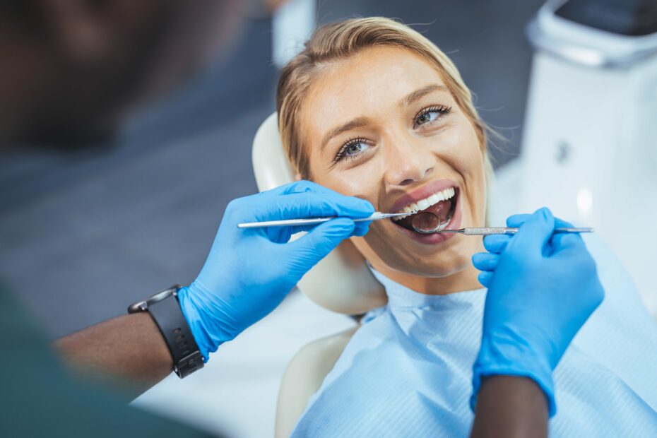 Attraktive junge Frau in der Stomatologie-Klinik mit männlichem Zahnarzt. Konzept für gesunde Zähne. Frau besucht ihren Zahnarzt. Zahnarzt diskutiert mit lächelnder Patientin