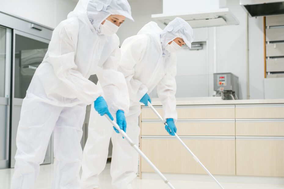 Fachkräfte bei der Reinraumreinigung wischen kontrolliert den Boden